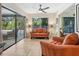 Bright living room with a ceiling fan, tile floors, and sliding glass doors leading to the outdoor pool area at 3900 Country View Dr, Sarasota, FL 34233