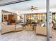 An outdoor lanai seating area with wicker furniture and a glass coffee table at 3900 Country View Dr, Sarasota, FL 34233