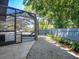 A screened-in lanai area showcases a beautiful pool and patio area, with lush landscaping and privacy fence at 3900 Country View Dr, Sarasota, FL 34233