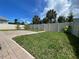 Spacious backyard featuring lush green grass, brick patio, mature landscaping, and a privacy fence at 4428 Conchfish Ln, Osprey, FL 34229