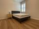 Bright bedroom with hardwood floors, a full bed, side table, and shuttered window at 4428 Conchfish Ln, Osprey, FL 34229