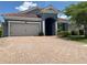 Charming single-story home with a brick driveway, two-car garage, and a terracotta roof at 4428 Conchfish Ln, Osprey, FL 34229