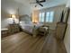 Well-lit main bedroom featuring a four-poster bed, wood floors, and plantation shutters at 4428 Conchfish Ln, Osprey, FL 34229