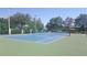 Bright and airy tennis court with a blue and green surface, surrounded by a green fence and mature trees at 4802 51St W St # 1313, Bradenton, FL 34210