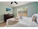 Bright, updated bedroom features a bed with white linens, a dresser, and a modern ceiling fan at 522 31St W St, Bradenton, FL 34205