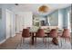A bright dining room with a table, pink chairs, and a view into the updated kitchen at 522 31St W St, Bradenton, FL 34205