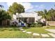 Charming white home features a blue front door, lush landscaping, and a well-manicured lawn at 522 31St W St, Bradenton, FL 34205
