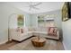 Bright living room with a white sectional sofa, wood floors, and soft pastel accents at 522 31St W St, Bradenton, FL 34205