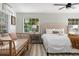 Inviting main bedroom featuring a plush king bed, a ceiling fan, and natural light at 522 31St W St, Bradenton, FL 34205