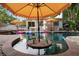 Stunning in-ground pool surrounded by umbrellas, lounge chairs, and lush tropical landscaping at 522 31St W St, Bradenton, FL 34205