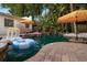 In-ground pool with fun floaties and lush tropical landscaping surrounding brick-paved patio at 522 31St W St, Bradenton, FL 34205