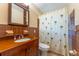 Bathroom with wood vanity, and shower with palm tree shower curtain at 5311 36Th E Ave, Palmetto, FL 34221