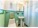 Retro bathroom with green tile, pedestal sink, and shower curtain at 5311 36Th E Ave, Palmetto, FL 34221