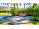 Private backyard oasis featuring a hot tub on a paver patio, surrounded by lush landscaping and a small pond at 5311 36Th E Ave, Palmetto, FL 34221