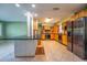 Bright eat-in kitchen with stainless refrigerator, tile floors, light wood cabinetry, and breakfast bar at 5311 36Th E Ave, Palmetto, FL 34221