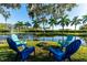 Inviting seating area around a fire pit, overlooking a serene pond with a fountain in a tropical setting at 5311 36Th E Ave, Palmetto, FL 34221