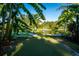 Backyard putting green with a pond view, fountain, and lush tropical surroundings at 5311 36Th E Ave, Palmetto, FL 34221