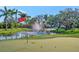 Beautiful Florida home featuring a putting green, pond with fountain, and an American flag waving in the breeze at 5311 36Th E Ave, Palmetto, FL 34221