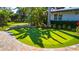 Manicured backyard featuring an artificial putting green, retaining wall, and brick paver border at 5311 36Th E Ave, Palmetto, FL 34221