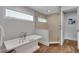 Bathroom with a large soaking tub and walk in shower with textured tile and wood flooring at 538 Canal Rd, Sarasota, FL 34242