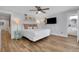 Relaxing bedroom with king bed, coastal decor, wood-look floors, tv, and ensuite bathroom at 538 Canal Rd, Sarasota, FL 34242