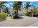 Three-story beach house with balconies, a two-car garage, and lush tropical landscaping at 538 Canal Rd, Sarasota, FL 34242