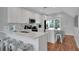 Modern white kitchen with stainless steel appliances, a large island with seating, and bright natural light at 538 Canal Rd, Sarasota, FL 34242