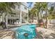 Resort-style pool with a built-in spa, bar stool seating, and lush landscaping at 538 Canal Rd, Sarasota, FL 34242