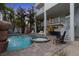 Pool in backyard with waterfall and attached jacuzzi surrounded by palm trees and entertainment areas at 538 Canal Rd, Sarasota, FL 34242