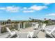Beautiful rooftop deck with white lounge furniture, ocean view, and metal railing at 538 Canal Rd, Sarasota, FL 34242