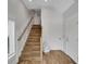 Bright entryway showcasing wood-look tile staircase with white risers and wood handrail at 538 Canal Rd, Sarasota, FL 34242