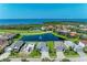 Stunning aerial view of homes surrounding a pond with ocean view in the distance at 5428 Title Row Dr, Bradenton, FL 34210