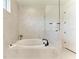 Bathroom featuring large soaking tub, neutral tiling, and glass enclosed shower at 5428 Title Row Dr, Bradenton, FL 34210
