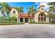 Exterior of a community clubhouse with columns, stucco finish, terracotta roof tiles and meticulously maintained landscaping at 5428 Title Row Dr, Bradenton, FL 34210