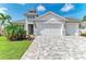 Beautiful home with lush landscaping, a brick driveway, and a three-car garage at 5428 Title Row Dr, Bradenton, FL 34210