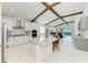 Open-concept kitchen featuring white cabinets, island with bar seating, and wooden beam accents at 5428 Title Row Dr, Bradenton, FL 34210