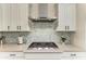 Modern kitchen features white cabinets, a stainless steel range hood, and stylish backsplash at 5428 Title Row Dr, Bradenton, FL 34210