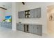 Living area with grey cabinets, wine refrigerator, and marble tile flooring at 5428 Title Row Dr, Bradenton, FL 34210