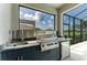 Outdoor kitchen area with stainless steel grill, sink, mini fridge, and granite countertop at 5428 Title Row Dr, Bradenton, FL 34210