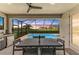 Screened lanai with dining area overlooking a pool, the lake, and beautiful landscaping at 5428 Title Row Dr, Bradenton, FL 34210