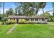 Charming single-story home featuring a well-manicured lawn and mature trees enhancing its curb appeal at 5430 Richardson Rd, Sarasota, FL 34232