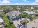 Aerial view of elegant single-story home with a gray garage door, lush landscaping, and a spacious brick driveway at 5569 Cape Leyte Dr, Sarasota, FL 34242