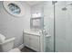 Stylish bathroom features a glass-enclosed shower, elegant vanity, and charming nautical-themed wallpaper at 5569 Cape Leyte Dr, Sarasota, FL 34242