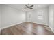 Bright, empty room with hardwood floors, neutral paint, and ample natural light from two windows at 5569 Cape Leyte Dr, Sarasota, FL 34242