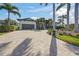 Stunning single-story home with a gray garage door, lush landscaping, and a spacious circular brick driveway at 5569 Cape Leyte Dr, Sarasota, FL 34242
