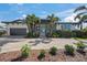 Beautiful single-story home featuring tropical landscaping, a brick driveway, and a covered entryway with charming blue doors at 5569 Cape Leyte Dr, Sarasota, FL 34242