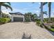Stunning single-story home featuring a gray garage door, lovely landscaping, and a spacious brick driveway at 5569 Cape Leyte Dr, Sarasota, FL 34242