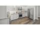 Gourmet kitchen featuring stainless steel appliances, white cabinets, granite countertops, and hardwood floors at 5569 Cape Leyte Dr, Sarasota, FL 34242