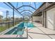 The pool and spa feature a screened enclosure providing stunning lake views and access to outdoor seating and cooking areas at 5569 Cape Leyte Dr, Sarasota, FL 34242