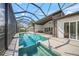 Captivating pool with a spa inside of a screened enclosure with clear views of lake, summer kitchen and outdoor seating at 5569 Cape Leyte Dr, Sarasota, FL 34242
